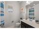 Bright bathroom featuring a single sink vanity, toilet, and shower with blue striped curtain at 1841 Sawyer Palm Pl, Kissimmee, FL 34747