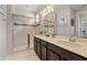 Bathroom featuring double sinks, granite countertops, and a glass-enclosed shower at 1841 Sawyer Palm Pl, Kissimmee, FL 34747