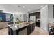 Open kitchen with granite island, stainless appliances, and seamless flow to living area at 1841 Sawyer Palm Pl, Kissimmee, FL 34747