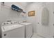 Bright laundry room features modern washer and dryer, shelving, and convenient access to ironing board at 1841 Sawyer Palm Pl, Kissimmee, FL 34747