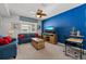 Stylish loft area with a blue accent wall, a TV, sofas, and comfortable seating at 1841 Sawyer Palm Pl, Kissimmee, FL 34747