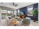 Well-lit living room with stylish furnishings, a dark blue accent wall, and a view of the outdoor pool at 1841 Sawyer Palm Pl, Kissimmee, FL 34747