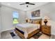 Comfortable bedroom with a cozy bed, wooden nightstands, a ceiling fan, and a view of the green lawn at 2121 West Pkwy, Deland, FL 32724