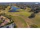 Overhead shot showcases the property's golf course frontage and backyard pool and lake in a lush neighborhood at 2313 Roat Dr, Orlando, FL 32835