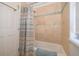 A tiled shower with a curtain, stone walls, and window in the bathroom at 2313 Roat Dr, Orlando, FL 32835