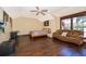 Bright bedroom boasts a ceiling fan, hardwood floors, large window, a bed, couch, and a quirky pirate flag above the bed at 2313 Roat Dr, Orlando, FL 32835