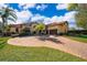 Elegant exterior showcases a circular brick driveway leading to a grand two-story home with manicured landscaping at 2313 Roat Dr, Orlando, FL 32835