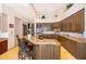 A kitchen with wood cabinets, a granite breakfast bar, stainless appliances, and recessed lighting at 2313 Roat Dr, Orlando, FL 32835