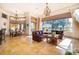 Open living room with stone floors, large windows, chandeliers, and view of breakfast nook at 2313 Roat Dr, Orlando, FL 32835