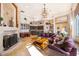 A living room with a fireplace, stone floors, chandeliers, and view of breakfast nook and kitchen at 2313 Roat Dr, Orlando, FL 32835