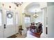 Inviting entryway featuring a decorative front door that leads into a dining room with pillars and a chandelier at 290 Thomas Dr, Casselberry, FL 32707
