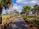 Scenic walking path lined with lush palm trees and greenery leads to a tranquil lake at 290 Thomas Dr, Casselberry, FL 32707