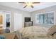 Bright bedroom features a ceiling fan, closet, window with blinds and a view, with a television atop a dresser at 2909 Depauw Ave, Orlando, FL 32804