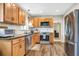 Open concept kitchen featuring wood-look floors, stainless steel appliances, and wooden cabinets at 2909 Depauw Ave, Orlando, FL 32804