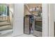 Modern laundry room featuring front-loading washer and dryer, overhead shelving and a spiral staircase in a well-lit space at 2909 Depauw Ave, Orlando, FL 32804