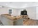 Modern living room featuring a sectional sofa, a large television, and stylish hardwood floors, perfect for relaxation at 2909 Depauw Ave, Orlando, FL 32804