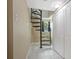 Elegant carpeted spiral staircase with white tile floors, complemented by natural light from a window at 2909 Depauw Ave, Orlando, FL 32804