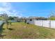 Fenced backyard with green grass, fire pit, and space for outdoor activities under a bright, sunny sky at 3117 Lake Mar Ln, Orlando, FL 32806