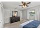Bright bedroom with a ceiling fan, closet, and dark wood dresser with a large mirror at 3117 Lake Mar Ln, Orlando, FL 32806