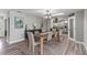 Open concept dining room with view into eat-in kitchen, featuring modern table and decor at 3117 Lake Mar Ln, Orlando, FL 32806