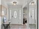 Inviting foyer with modern light fixture, mirrors, and stylish console table at 3117 Lake Mar Ln, Orlando, FL 32806