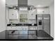 Close up of kitchen with stainless steel appliances, granite countertops and large island with overhead vent hood at 3117 Lake Mar Ln, Orlando, FL 32806