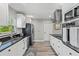 Modern kitchen featuring white cabinets, granite countertops, stainless steel appliances, and wood-look flooring at 3117 Lake Mar Ln, Orlando, FL 32806