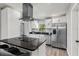 Bright kitchen featuring white cabinets, granite countertops, stainless steel appliances, and a modern vent hood at 3117 Lake Mar Ln, Orlando, FL 32806