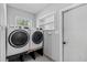 Laundry room with a side-by-side washer and dryer, a window, and a white door at 3117 Lake Mar Ln, Orlando, FL 32806