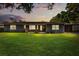 Well-maintained home with manicured lawn and beautiful landscaping at dusk at 4210 Shorecrest Dr, Orlando, FL 32804