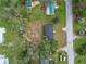 Aerial view showcasing the home's roof, mature trees, surrounding buildings and street at 5045 Se 148Th St, Summerfield, FL 34491