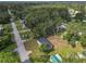 Aerial view of a charming single story home featuring a spacious yard with mature trees and a peaceful neighborhood at 5045 Se 148Th St, Summerfield, FL 34491