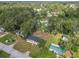 Aerial view of a home boasting a well-maintained lawn, mature trees, and various sheds and outbuildings at 5045 Se 148Th St, Summerfield, FL 34491