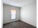 Cozy bedroom with neutral carpet, walls, and a window with blinds and simple curtains at 5045 Se 148Th St, Summerfield, FL 34491