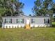 Charming gray home with black shutters and well-maintained landscaping at 5045 Se 148Th St, Summerfield, FL 34491