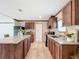 Well-lit kitchen with dark wood cabinets, stainless steel sink, and modern appliances at 5045 Se 148Th St, Summerfield, FL 34491