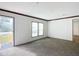 Bright living room featuring fresh neutral paint, plush carpeting, and a large window overlooking the landscaped lawn at 5045 Se 148Th St, Summerfield, FL 34491