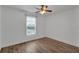 Bright bedroom with hardwood floors, ceiling fan, and a large window with natural light at 5852 Mariposa Cove Ln, Orlando, FL 32822