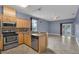 Open concept kitchen with stainless steel appliances, light wood cabinets, and granite countertops at 5852 Mariposa Cove Ln, Orlando, FL 32822
