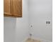 A small laundry area with overhead wooden cabinet and hookups at 5852 Mariposa Cove Ln, Orlando, FL 32822