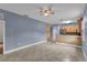 Open-concept living room with tile floors, ceiling fan and kitchen access at 5852 Mariposa Cove Ln, Orlando, FL 32822