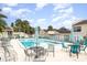 Community pool with tables, lounge chairs, clear blue water and palm trees at 604 Desoto Dr, Casselberry, FL 32707