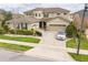 Beautiful two-story home showcasing a manicured lawn, stone accents, and an attached two-car garage at 619 Oxford Chase Dr, Winter Garden, FL 34787