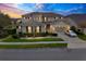 Stunning two-story home featuring a manicured lawn, stone accents, and an attached two-car garage at 619 Oxford Chase Dr, Winter Garden, FL 34787