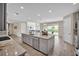 Bright kitchen with a large island, stainless steel appliances, gray cabinets, and access to the outdoor patio at 619 Oxford Chase Dr, Winter Garden, FL 34787