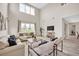 Sun-filled living room features soaring ceilings, large windows and hardwood flooring at 619 Oxford Chase Dr, Winter Garden, FL 34787