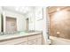 Bright bathroom features double vanity with granite countertop and shower-tub combination at 7219 Oakmoss Loop, Davenport, FL 33837