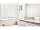 Bright bathroom featuring granite countertops, a framed print, window with blinds, and a decorative wall mirror at 7219 Oakmoss Loop, Davenport, FL 33837