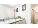 Bathroom featuring double vanity with granite countertop and framed butterfly art at 7219 Oakmoss Loop, Davenport, FL 33837