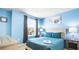 Relaxing bedroom with blue walls, comfortable bed, and plenty of natural light at 7219 Oakmoss Loop, Davenport, FL 33837